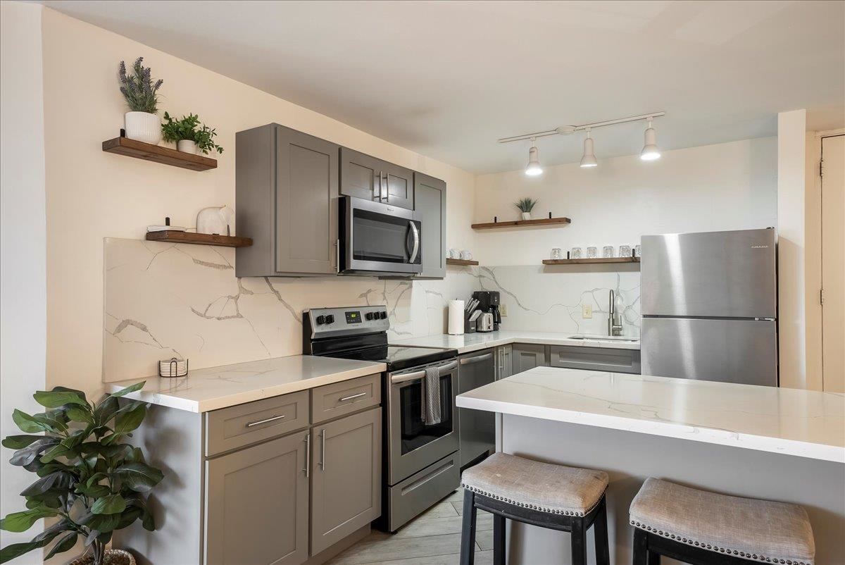 938 South Kihei Road, Unit 423 Kihei, HI 96753 - Photo 5 of 50 a kitchen with a refrigerator a stove a sink a dining table and chairs