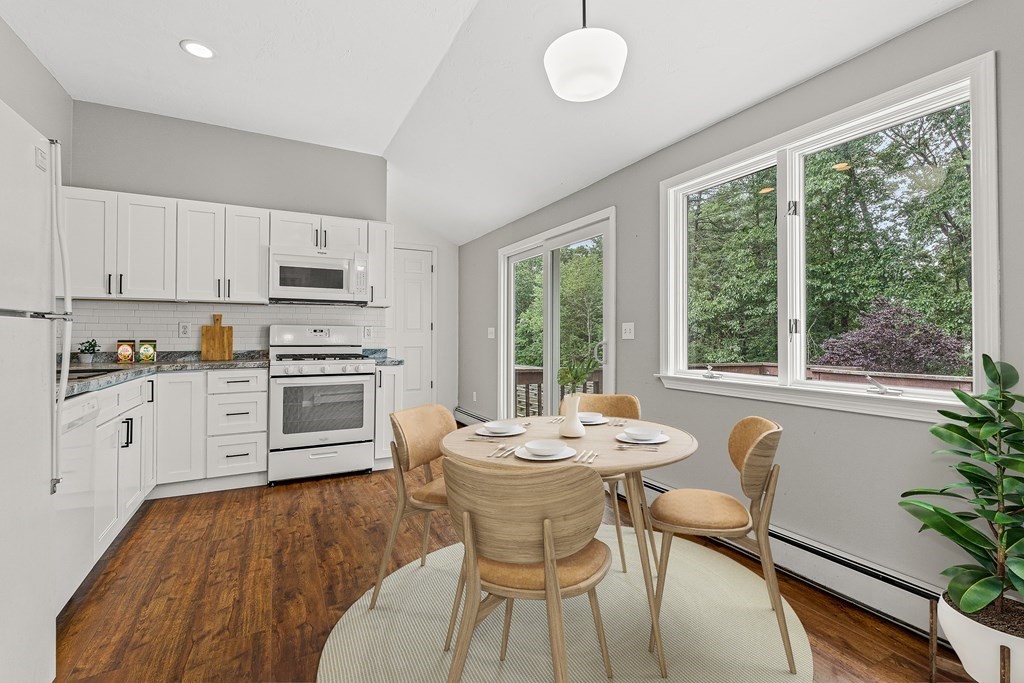 7 Cynthia Road Billerica, MA 01821 - Photo 33 of 41 a kitchen with a table chairs stove and white cabinets