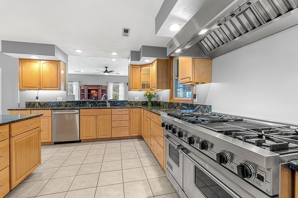 7 Cynthia Road Billerica, MA 01821 - Photo 8 of 41 a kitchen with stainless steel appliances granite countertop a stove a sink dishwasher and white cabinets with wooden floor