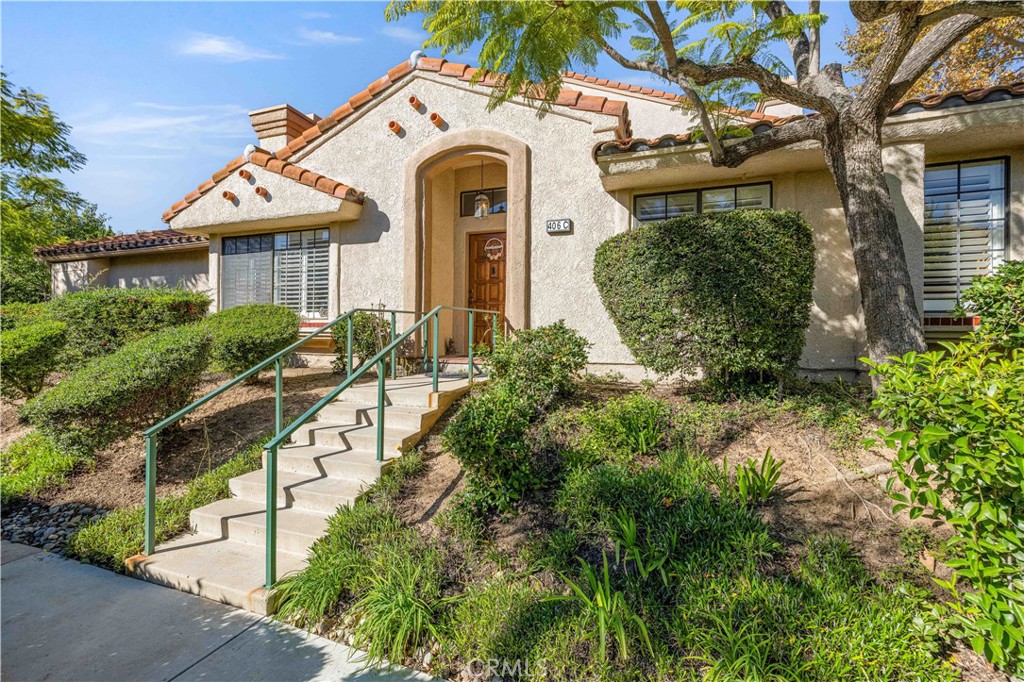 406 Country Club Drive Simi Valley, CA 93065 - Photo 18 of 56 a front view of a house with a yard and potted plants