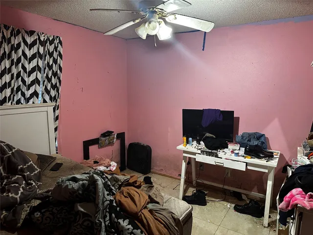 a bedroom with a bed and a computer on a desk