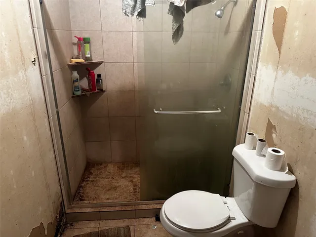 a bathroom with a toilet and a shower