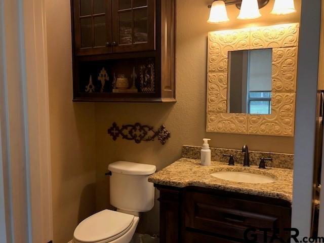 19330 Brittni Rae Court Lindale, TX 75771 - Photo 12 of 14 a bathroom with a granite countertop toilet and a sink