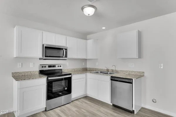 a kitchen with white cabinets stainless steel appliances and sink