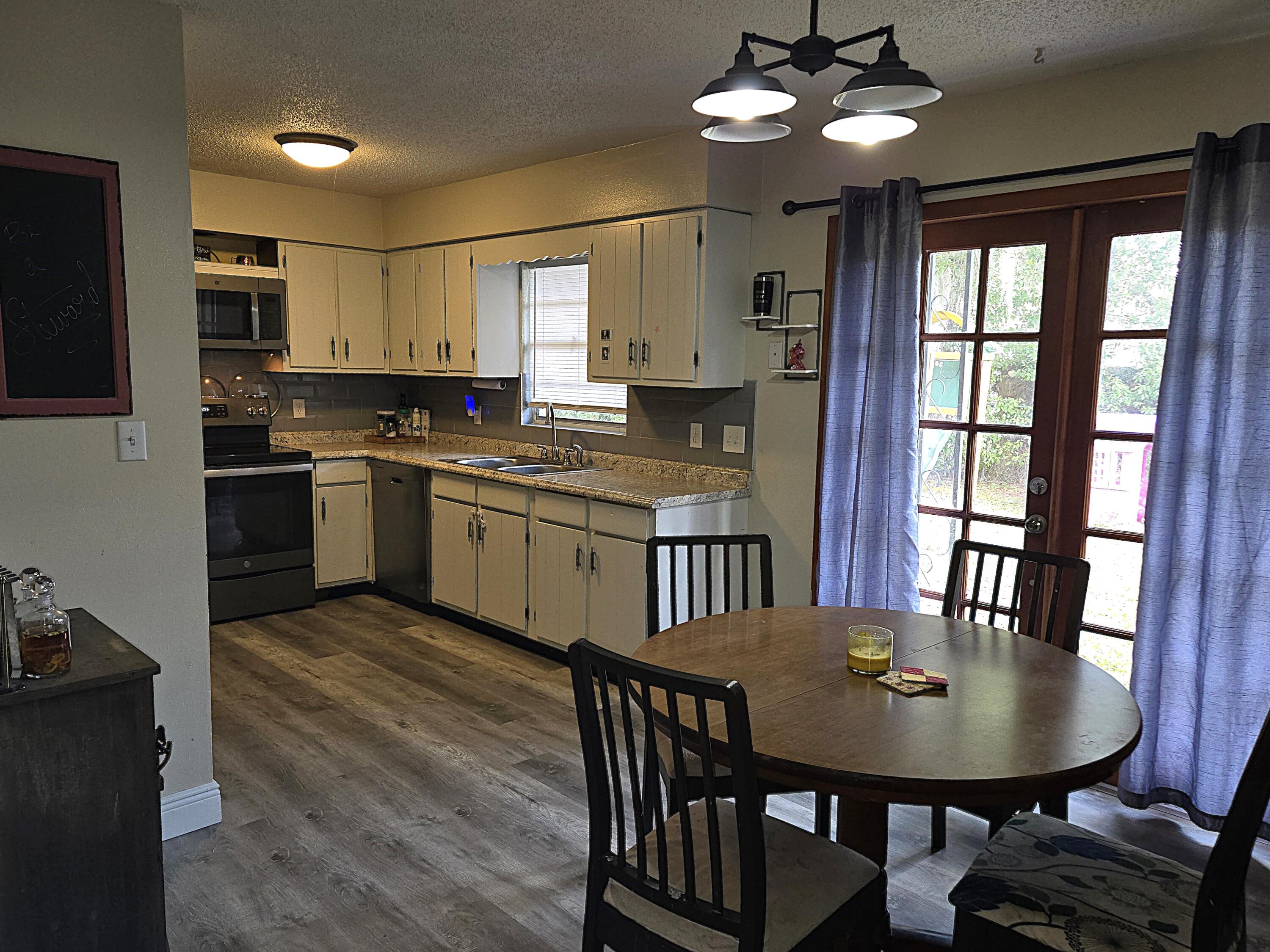 211 Northeast 3rd Terrace Williston, FL 32696 - Photo 13 of 46 a view of a dining room with furniture window and wooden floor