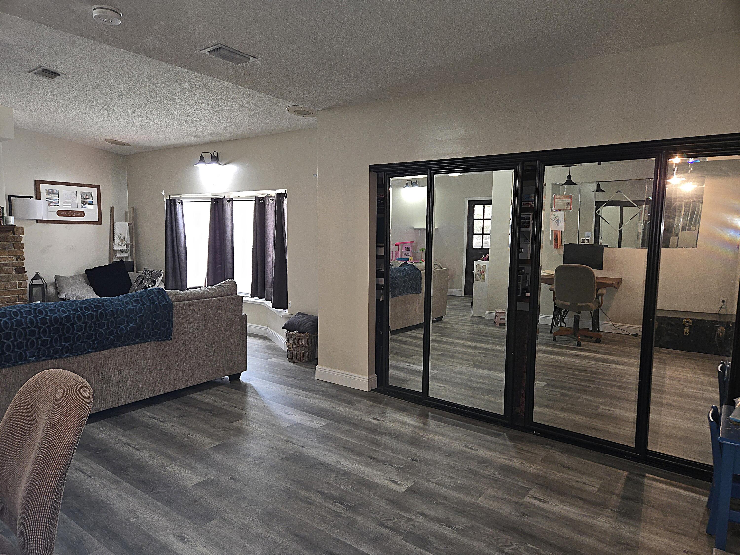 211 Northeast 3rd Terrace Williston, FL 32696 - Photo 16 of 46 a living room with furniture and wooden floor
