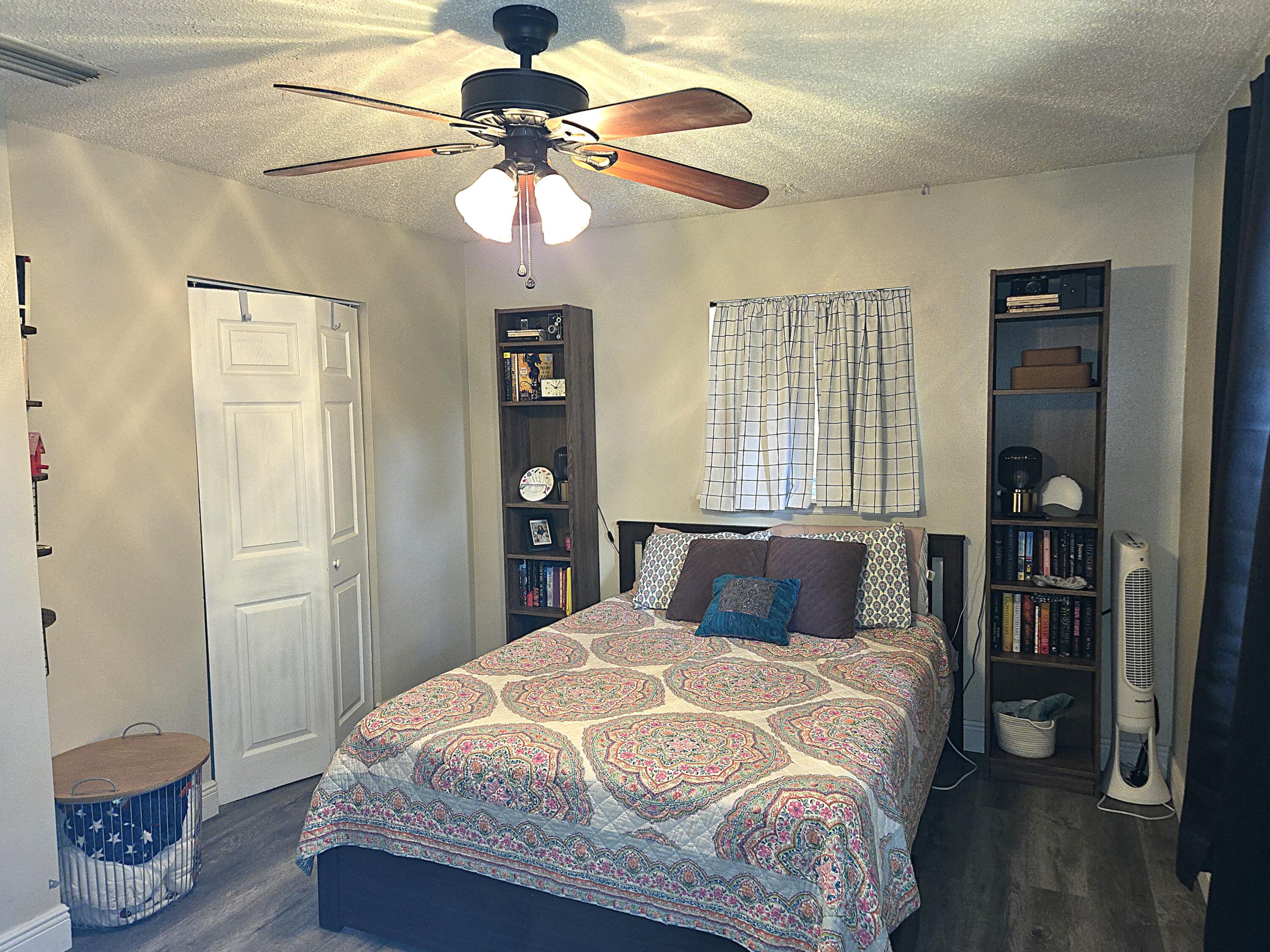 211 Northeast 3rd Terrace Williston, FL 32696 - Photo 30 of 46 a bedroom with a bed and a chandelier