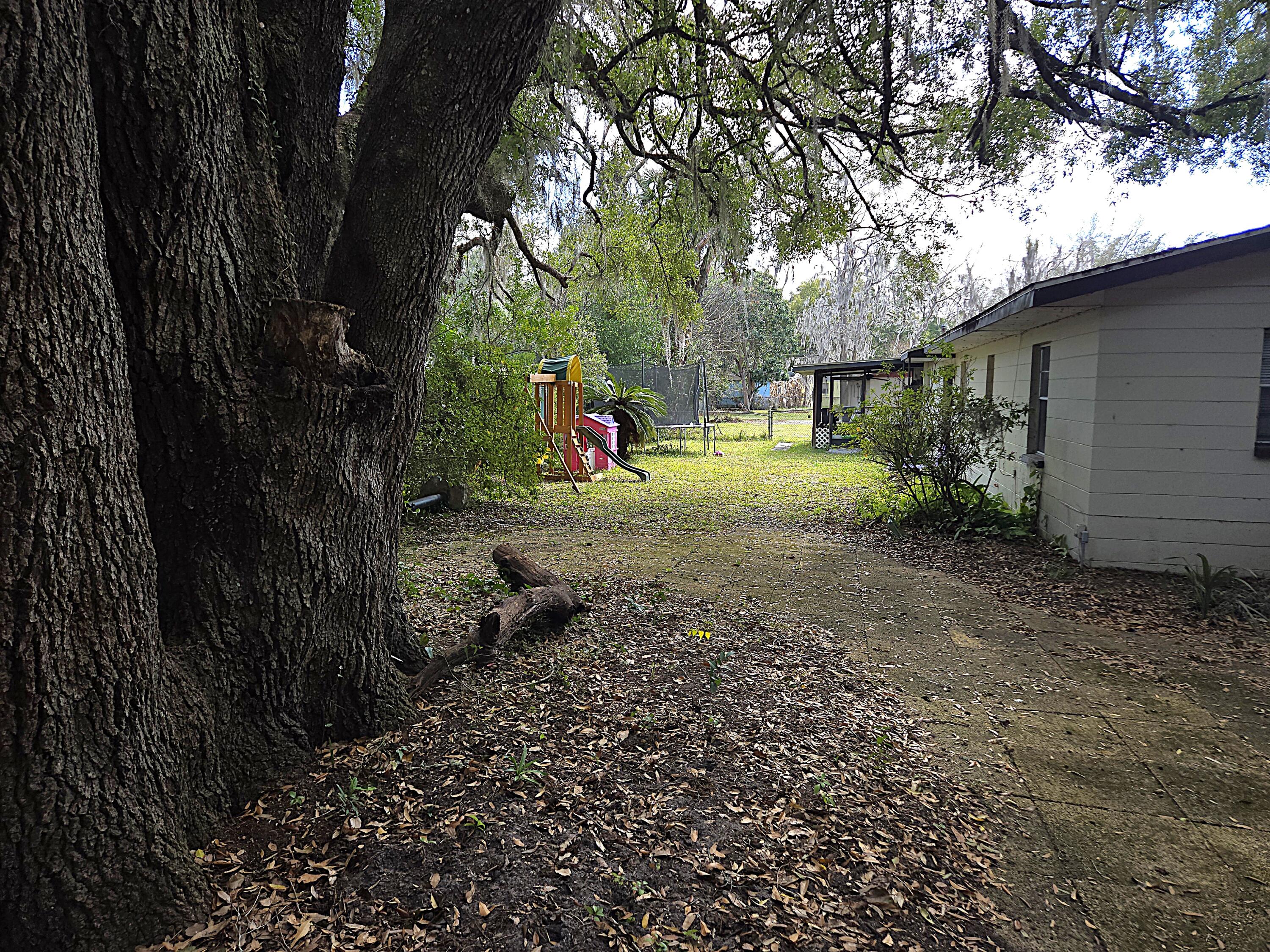 211 Northeast 3rd Terrace Williston, FL 32696 - Photo 41 of 46 a backyard of a house with table and chairs under an umbrella