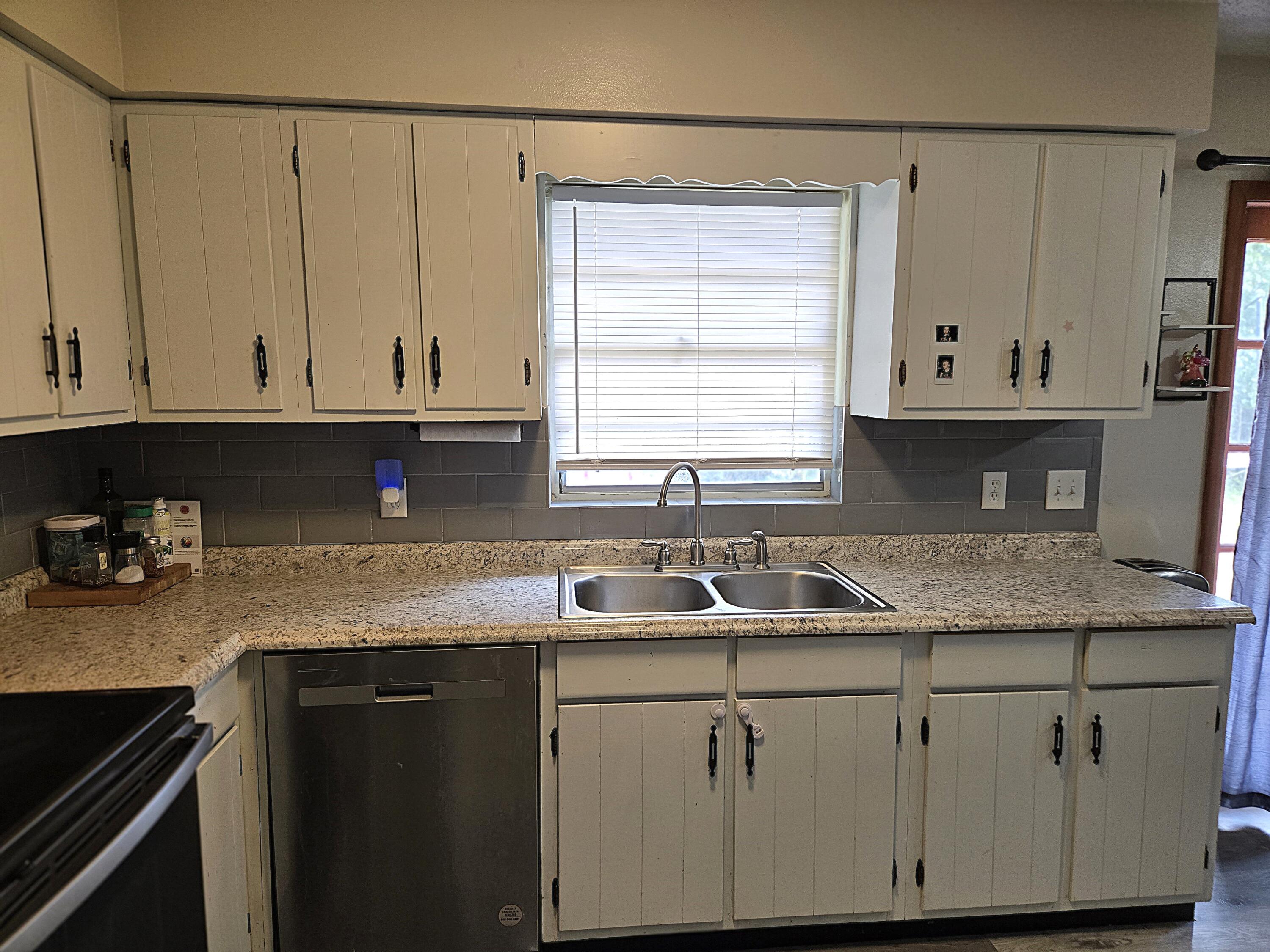 211 Northeast 3rd Terrace Williston, FL 32696 - Photo 6 of 46 a kitchen with granite countertop a sink a stove and cabinets