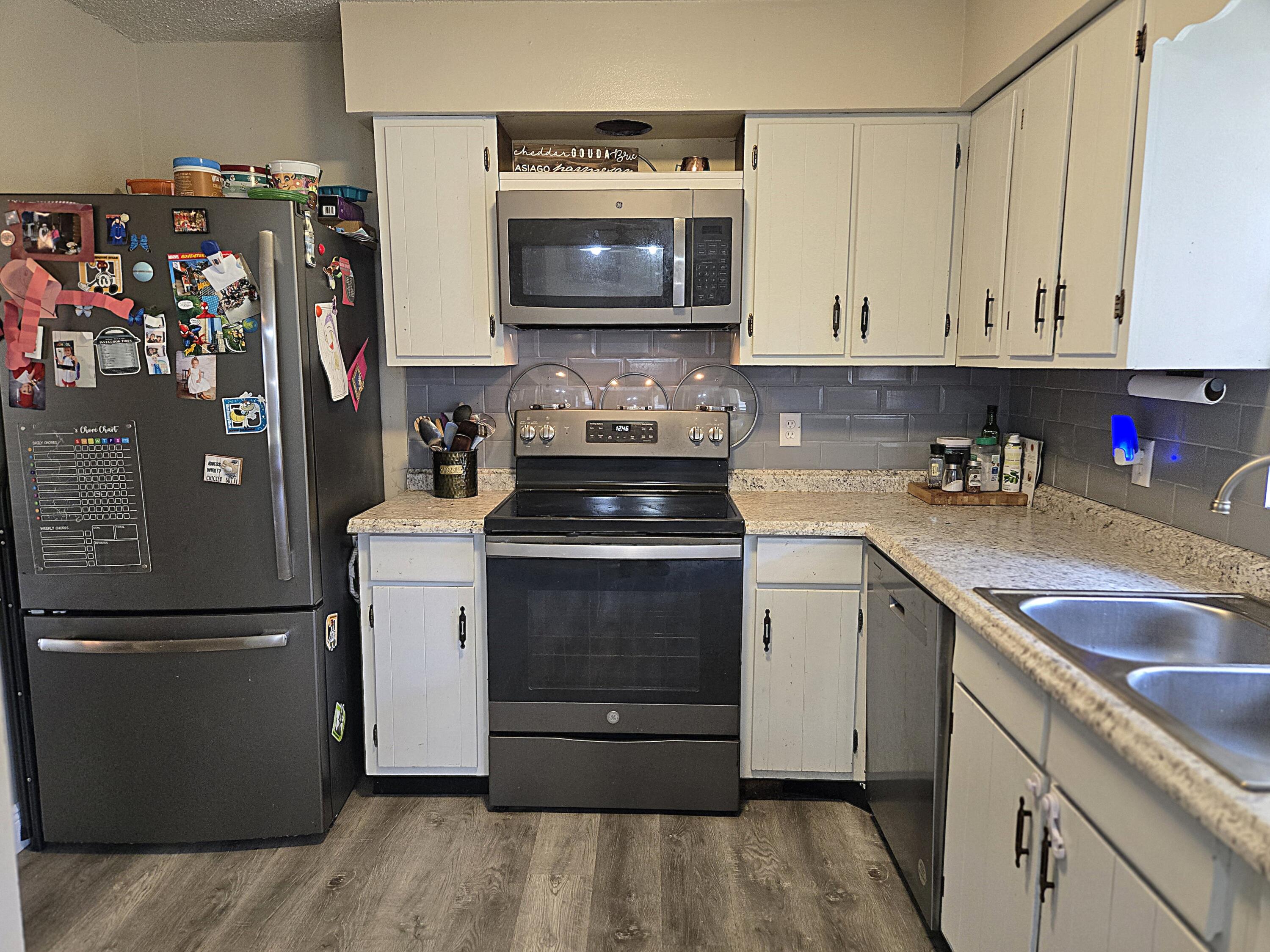 211 Northeast 3rd Terrace Williston, FL 32696 - Photo 7 of 46 a kitchen with stainless steel appliances granite countertop a stove a refrigerator and a sink