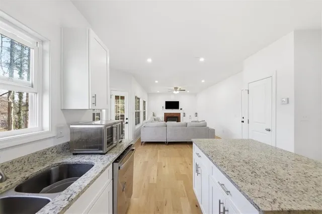 a large kitchen with kitchen island a large counter top space a sink stainless steel appliances and windows