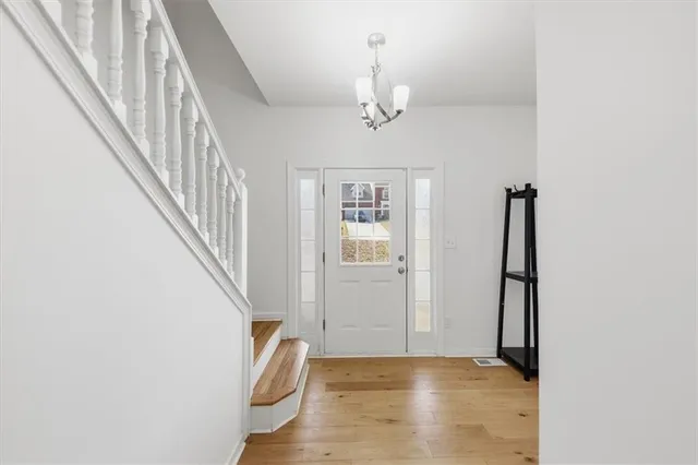 a view of a hallway with wooden floor and staircase
