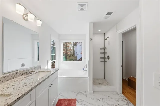 a bathroom with a granite countertop sink mirror and shower