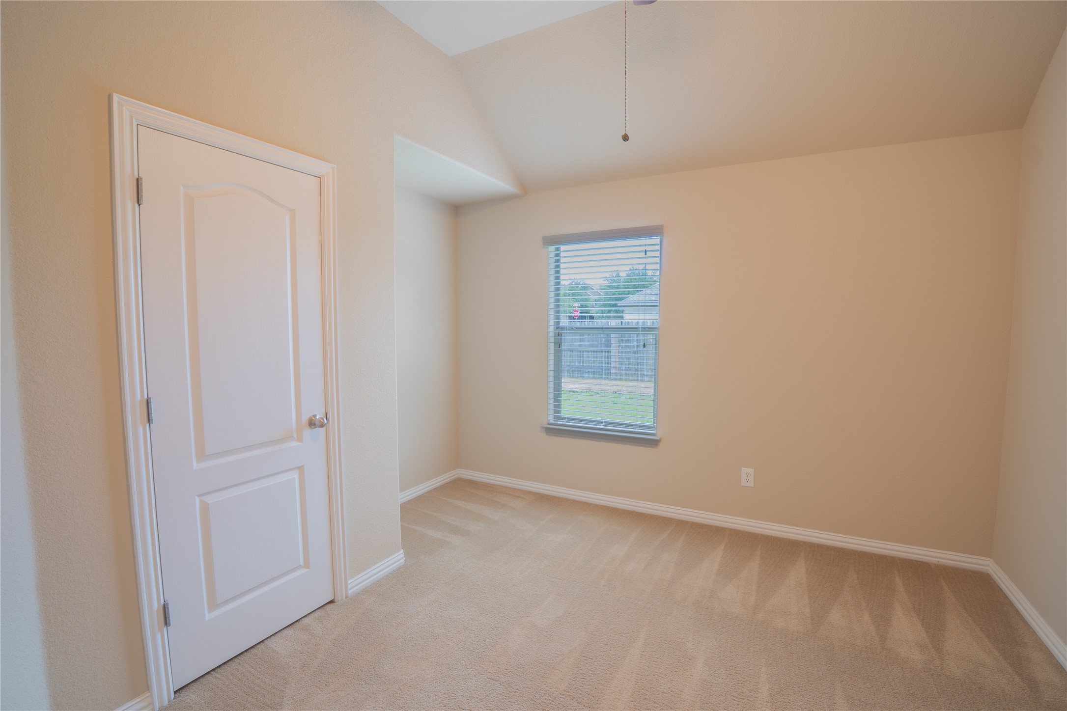 403 Tascate Street Georgetown, TX 78628 - Photo 15 of 26 An inviting room boasts soft carpeting, a window for natural light, and vaulted ceilings.