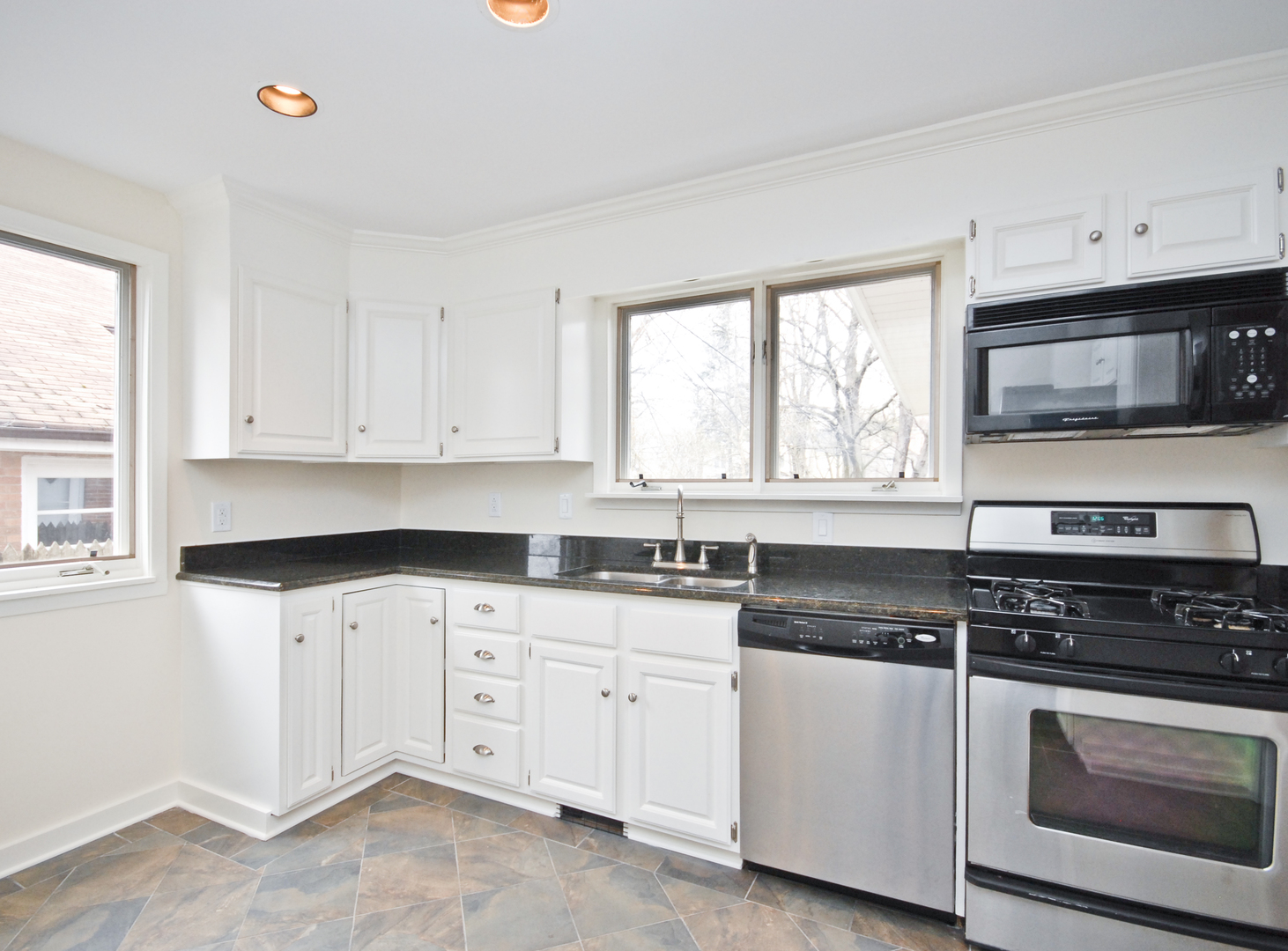 1149 Willow Road Winnetka, IL 60093 - Photo 11 of 37 a kitchen with granite countertop white cabinets sink and window