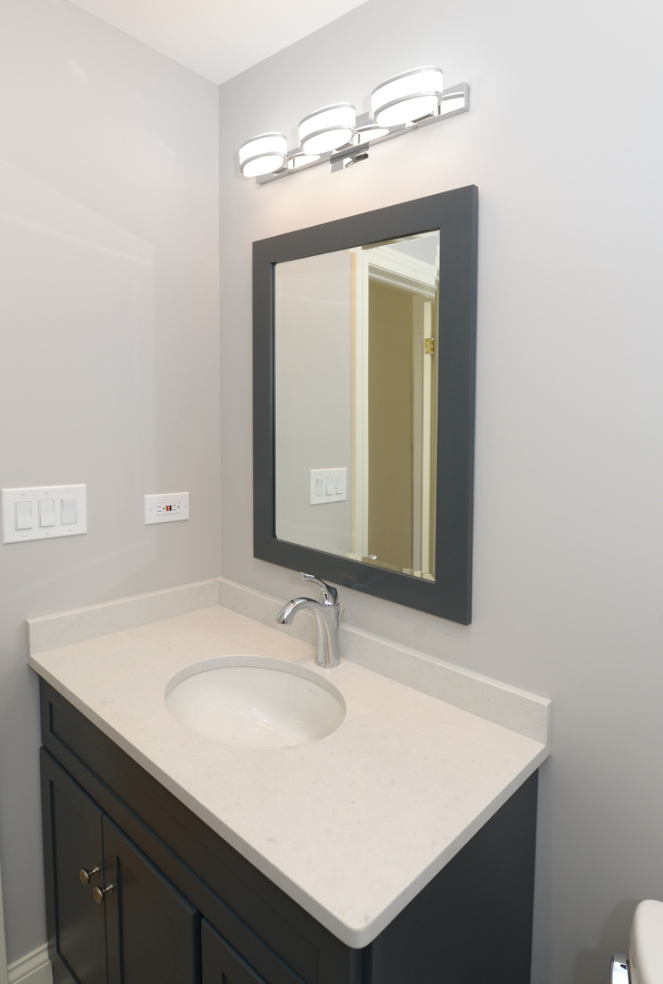 1149 Willow Road Winnetka, IL 60093 - Photo 23 of 37 a bathroom with a sink vanity and a mirror