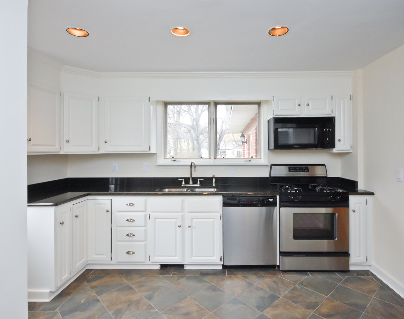 1149 Willow Road Winnetka, IL 60093 - Photo 10 of 37 a kitchen with granite countertop a stove a sink and a microwave