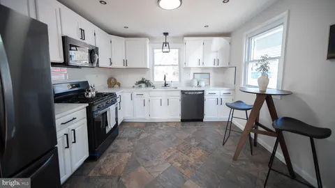 a kitchen with white cabinets stainless steel appliances and a refrigerator
