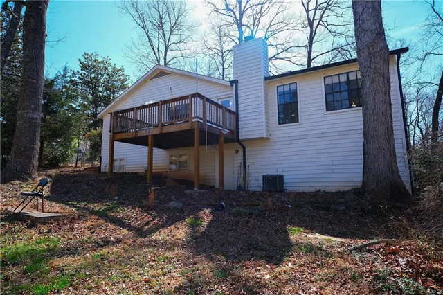 a view of a house with a yard and large tree