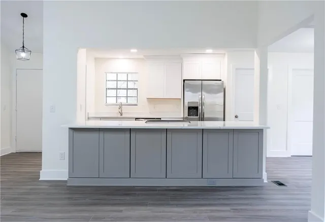 a view of kitchen with granite countertop white cabinets and wooden floor