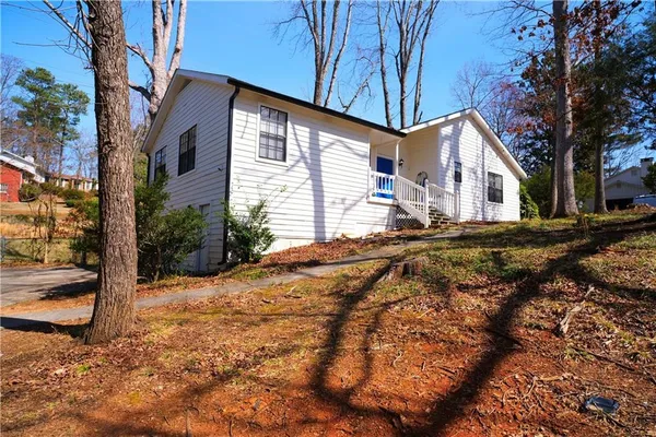 a backyard of a house with large trees and covered with tall trees
