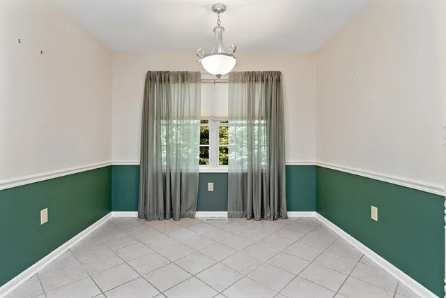 a view of a room that has a large window and chandelier