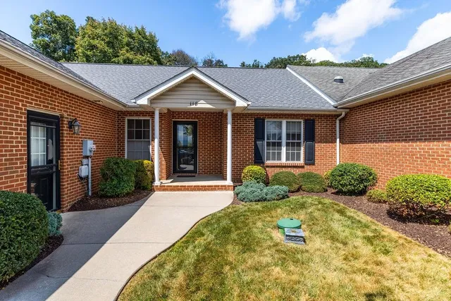 a view of a white house with large windows and plants