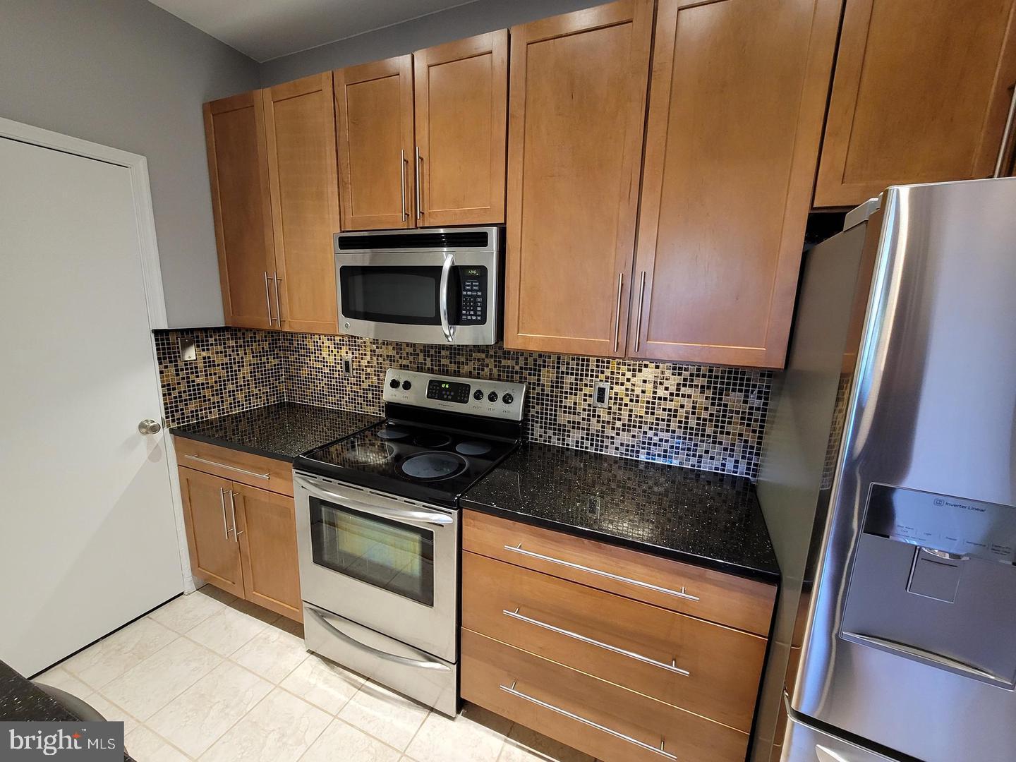 3908 Penderview Drive, Unit 608 Fairfax, VA 22033 - Photo 2 of 10 a kitchen with granite countertop a stove microwave and refrigerator