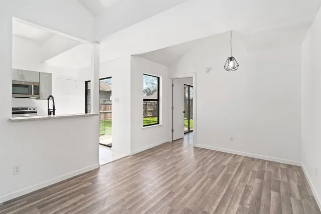 a view of a kitchen with wooden floor and a window