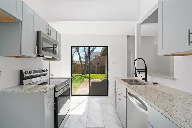 a kitchen with a sink and a stove top oven