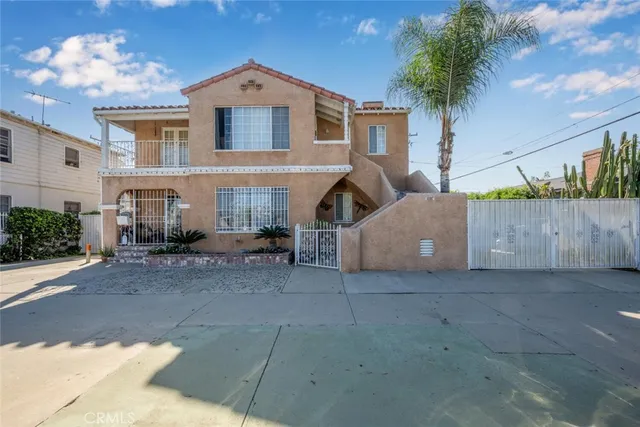 a view of a house with a yard and potted plants