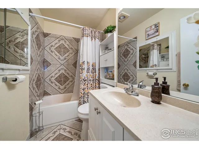a bathroom with a sink a mirror a bathtub and shower