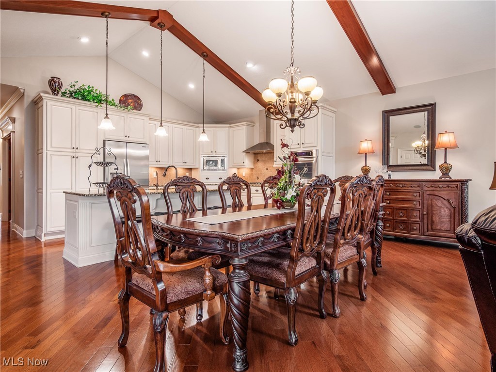 5349 Slater Ridge Westerville, OH 43082 - Photo 13 of 50 Dining space featuring beamed ceiling, dark wood-type flooring, a chandelier, and high vaulted ceiling