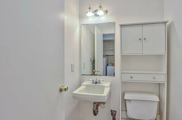 a bathroom with a toilet sink and mirror