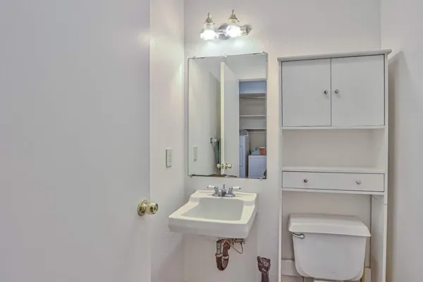 a bathroom with a sink a toilet and mirror