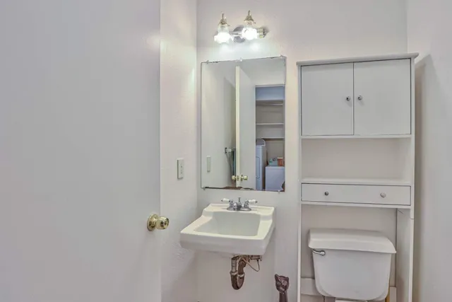 a bathroom with a sink a toilet and mirror