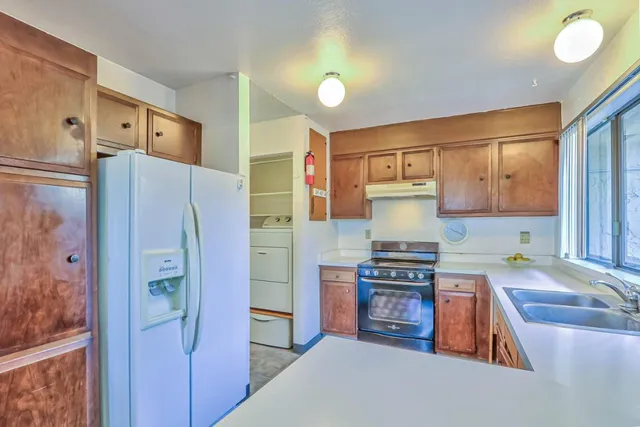 a kitchen with stainless steel appliances granite countertop a refrigerator and a stove