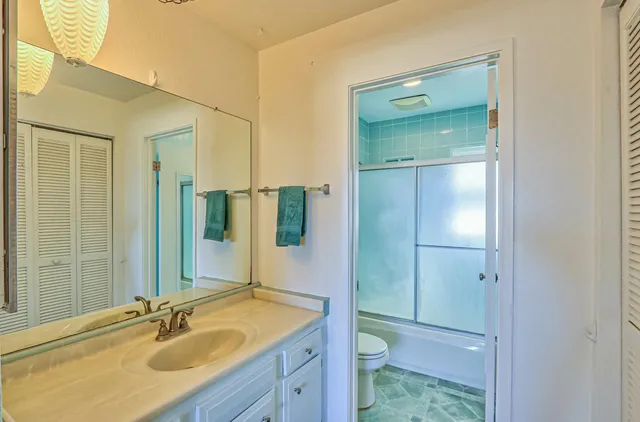 a bathroom with a sink shower and a mirror