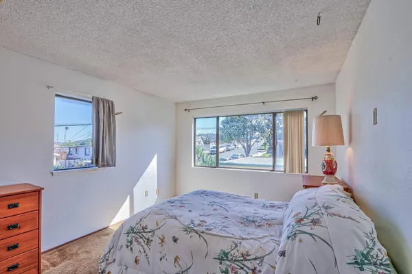 a bed sitting in a bedroom next to a window