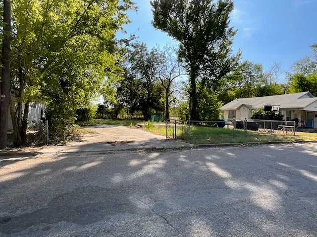 a view of street with houses and trees in the background