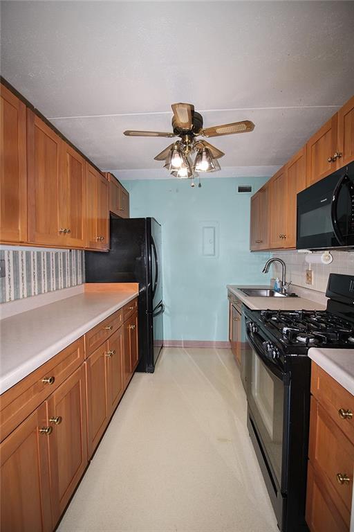 1150 Bower Hill Road, Unit 912A Pittsburgh, PA 15243 - Photo 20 of 39 a kitchen with stainless steel appliances a sink a stove top oven a chimney cabinets and a counter top space