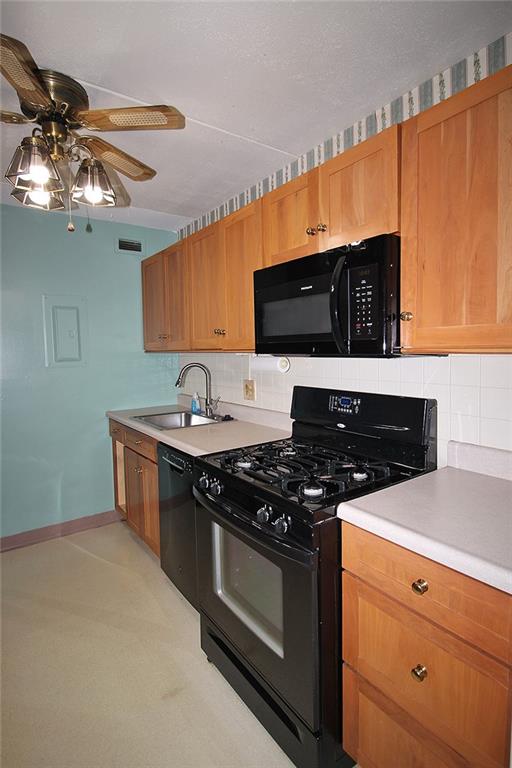 1150 Bower Hill Road, Unit 912A Pittsburgh, PA 15243 - Photo 21 of 39 a kitchen with stainless steel appliances a stove a microwave and wooden cabinets