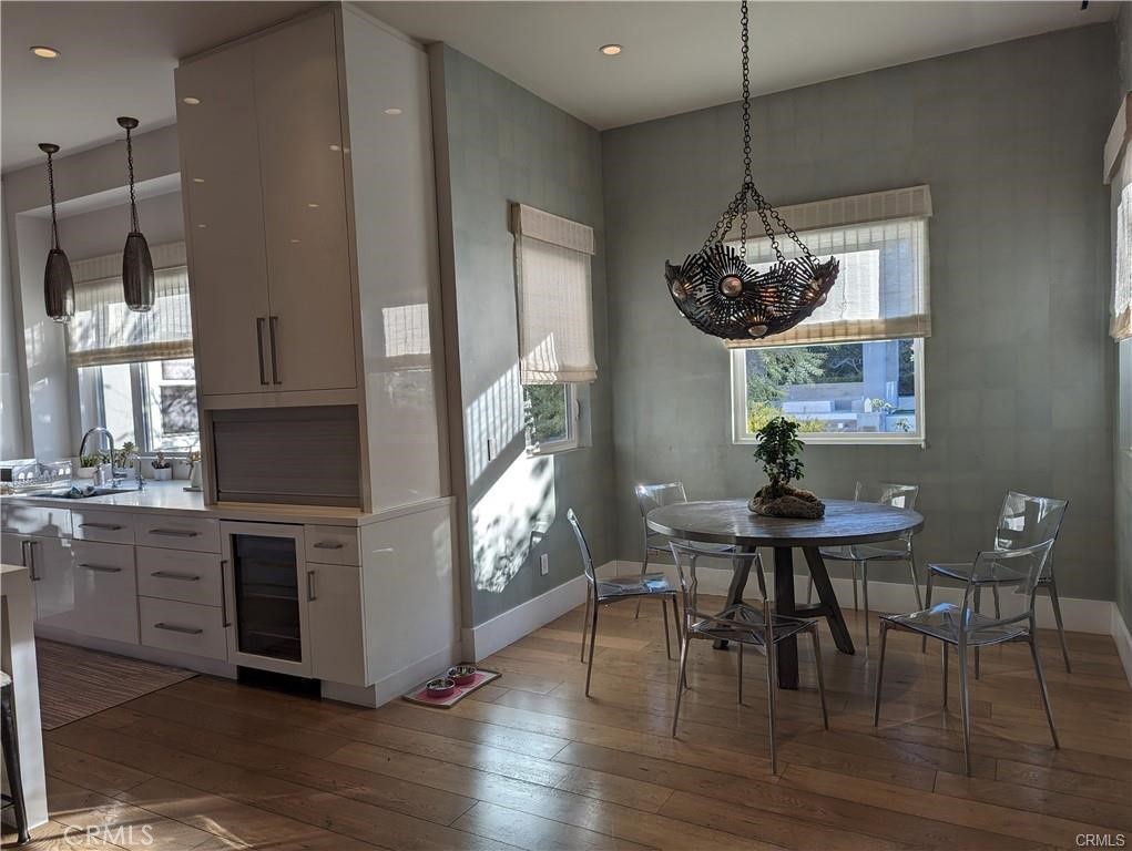 17950 Rancho Street Encino, CA 91316 - Photo 11 of 35 a kitchen with stainless steel appliances granite countertop a table chairs and a wooden floor