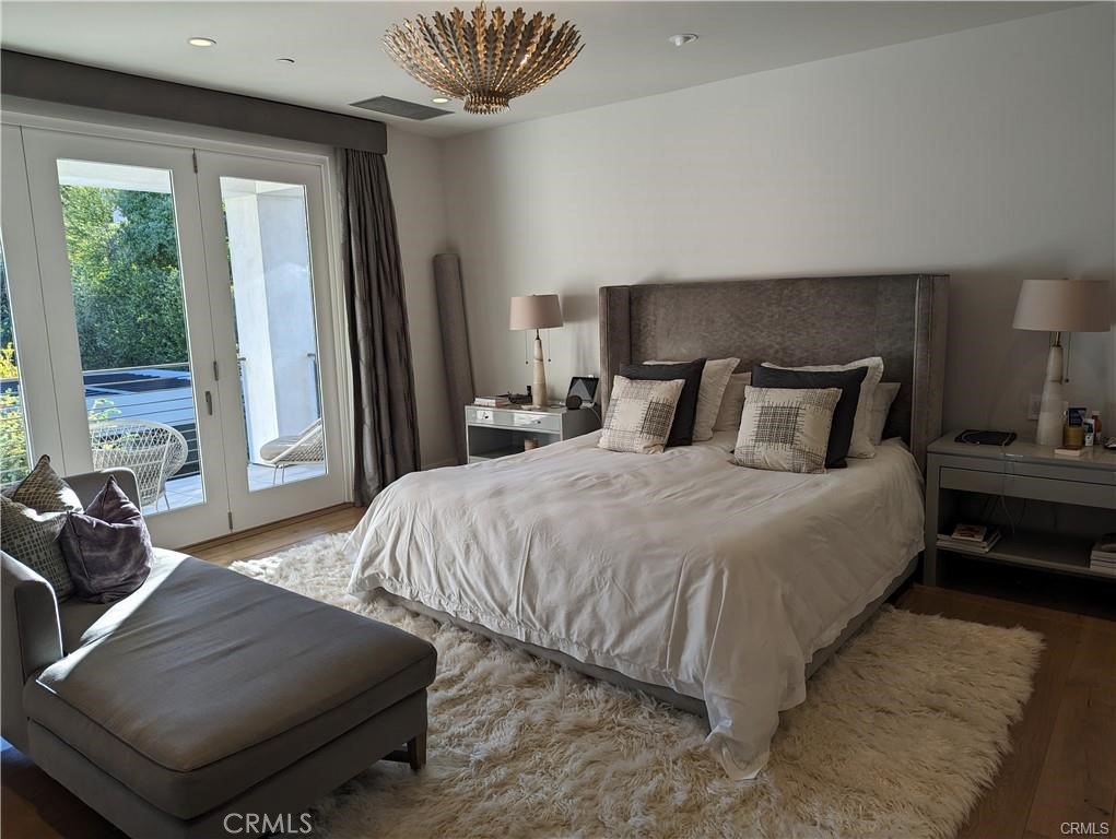 17950 Rancho Street Encino, CA 91316 - Photo 15 of 35 a bedroom with a bed and wooden floor