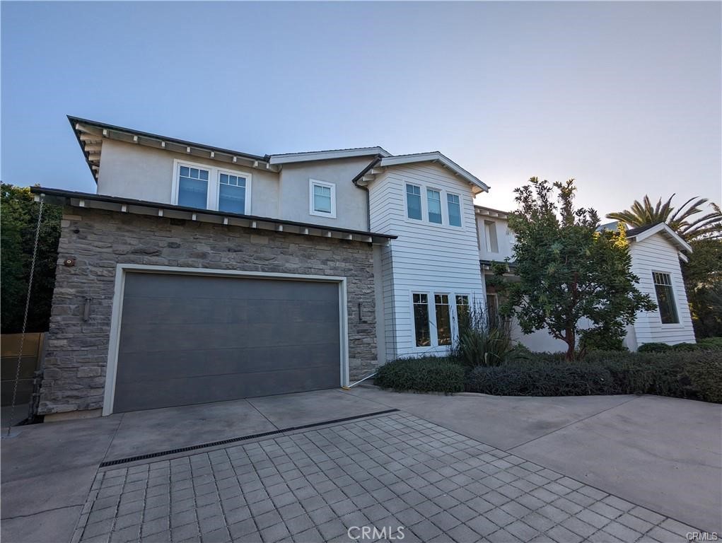 17950 Rancho Street Encino, CA 91316 - Photo 2 of 35 a front view of a house with a yard and garage