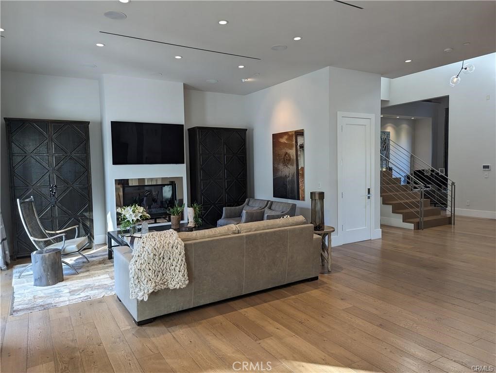 17950 Rancho Street Encino, CA 91316 - Photo 4 of 35 a living room with furniture a fireplace and a flat screen tv