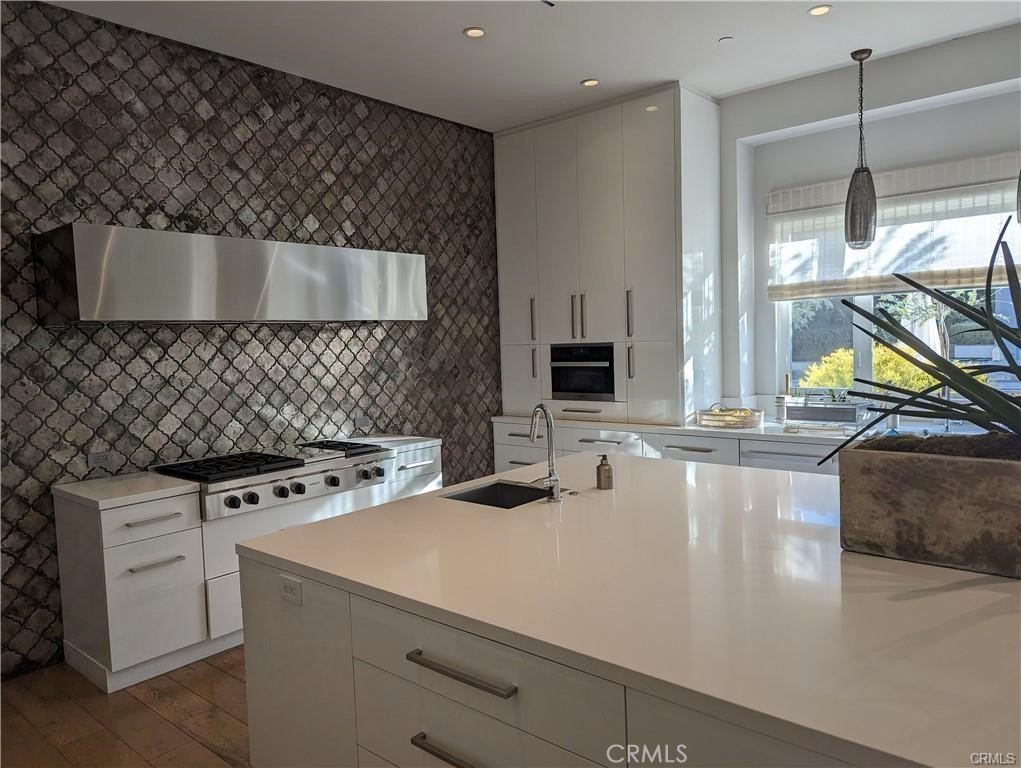 17950 Rancho Street Encino, CA 91316 - Photo 8 of 35 a kitchen with a stove a sink and a microwave
