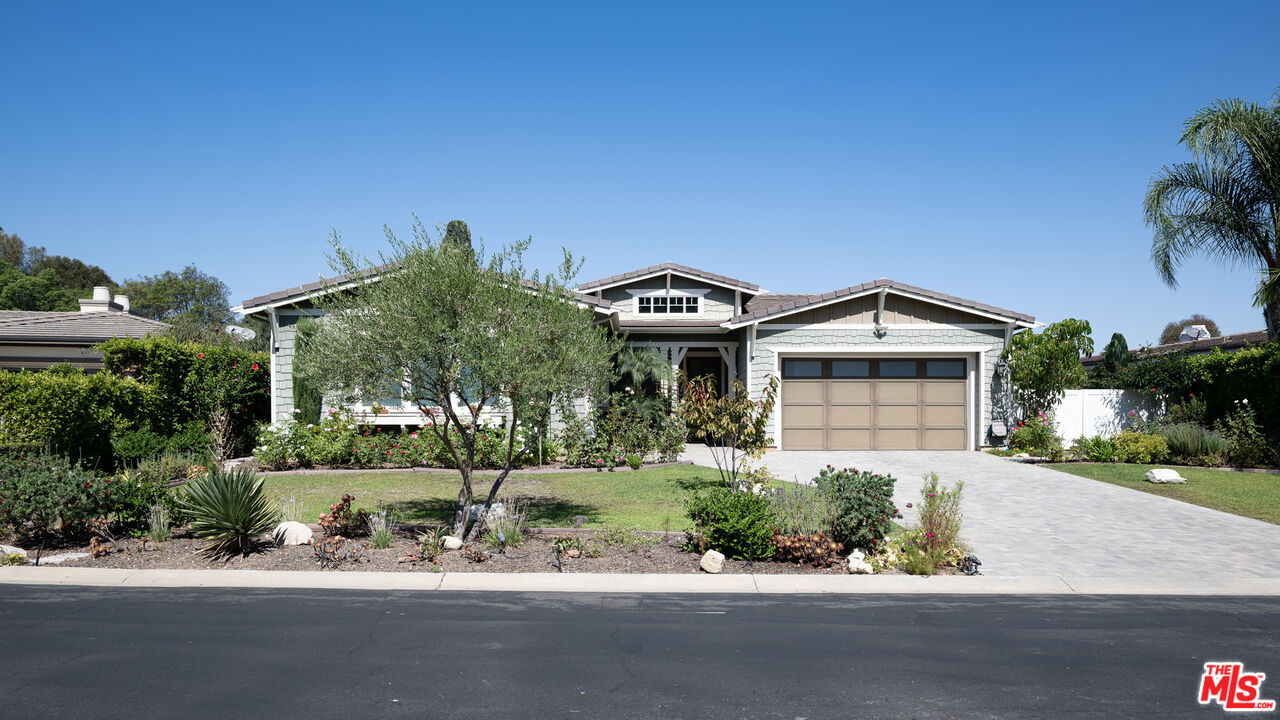 a front view of a house with a yard and potted plants