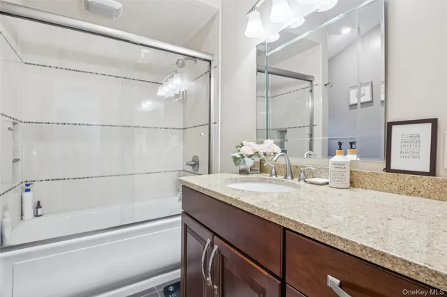 a bathroom with a granite countertop sink a toilet and shower