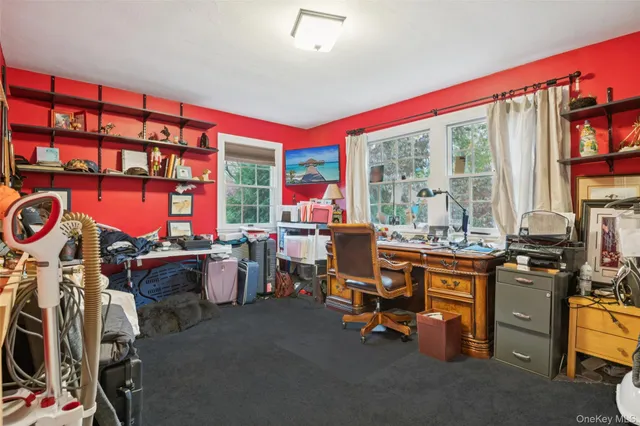 a view of a workspace with furniture and a large window